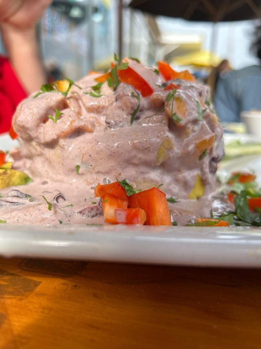 Causa limeña, the classic mound, with chopped tomato and herbs