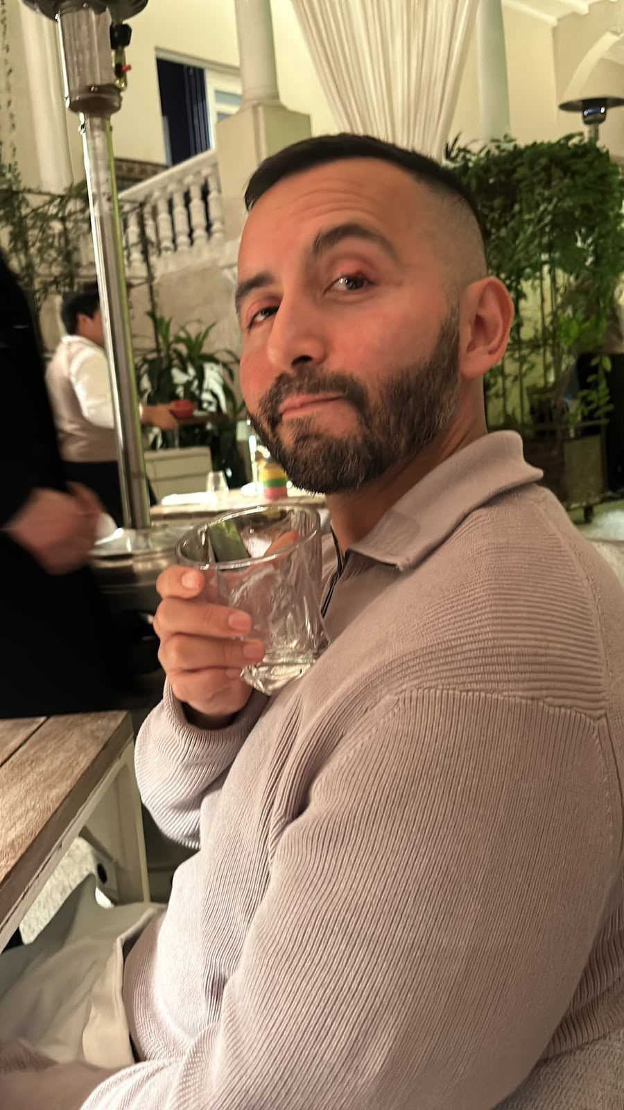 A guest raising a pisco sour at a colonial patio